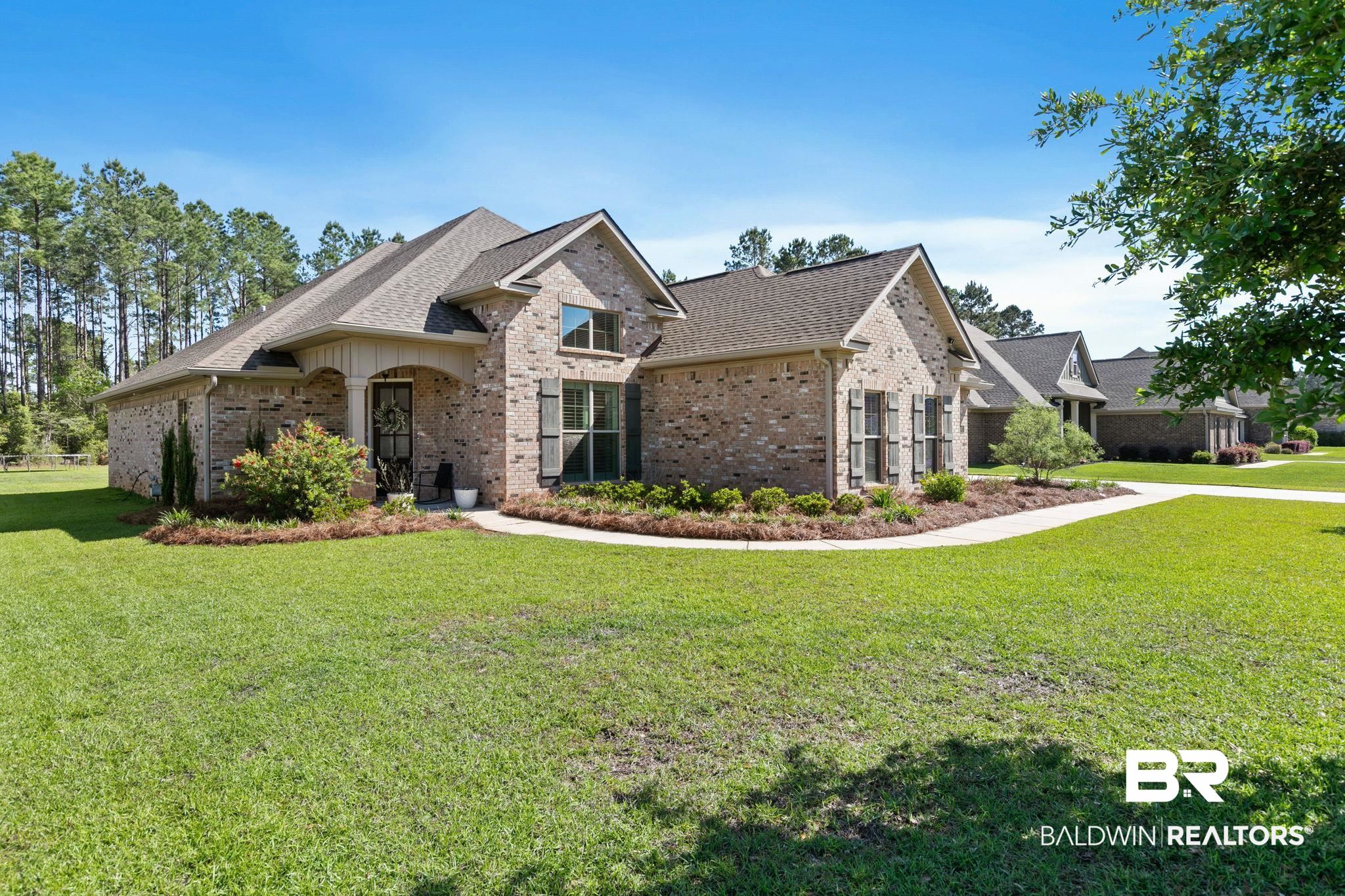 31911 Bobwhite Road Daphne, AL 36527 - Photo 78 of 85 View of front of house with brick siding, a front yard, and a shingled roof
