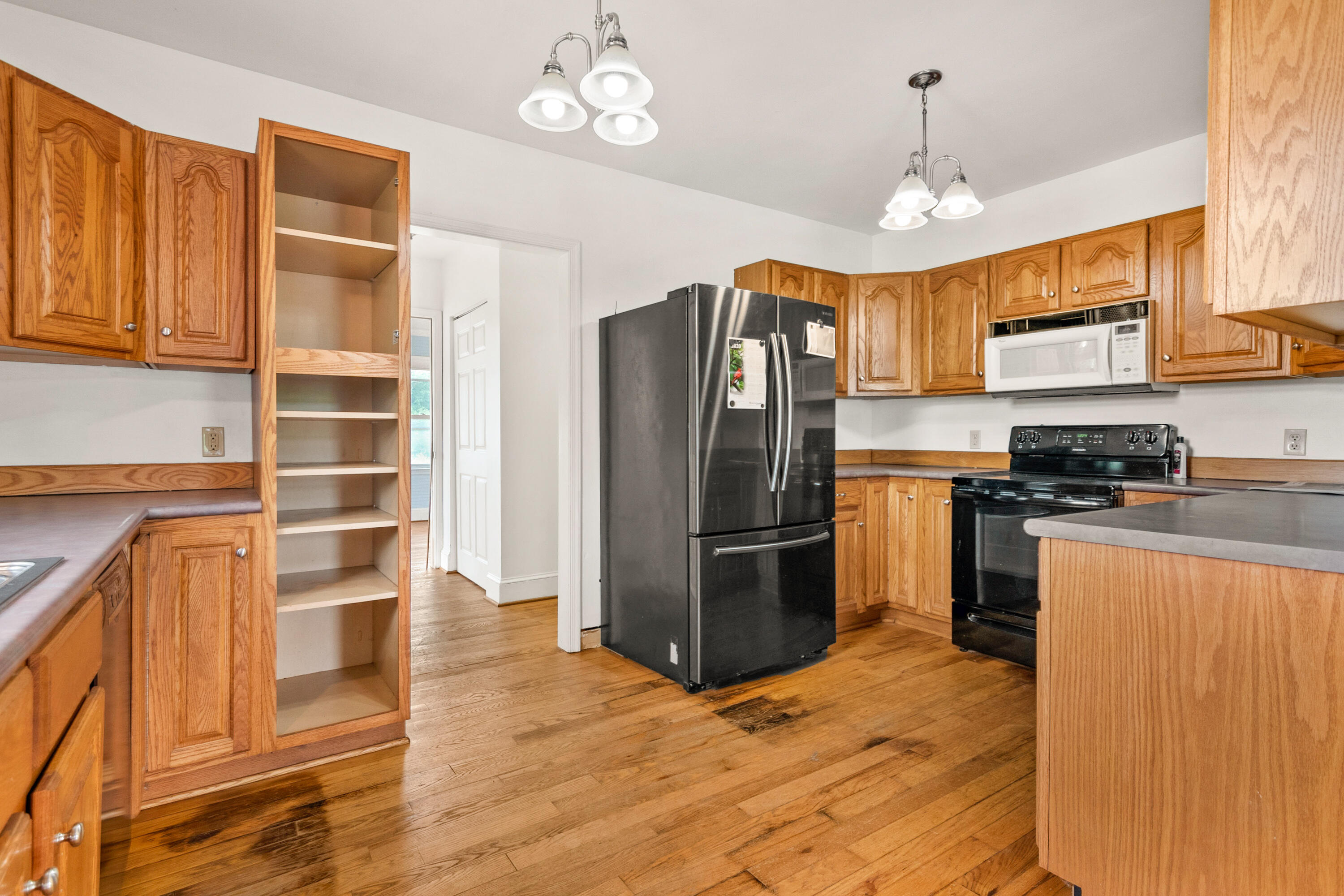 223 Conner Grove Road Southwest Willis, VA 24380 - Photo 14 of 74 a kitchen with stainless steel appliances granite countertop a refrigerator a sink dishwasher a stove and a dining table with wooden floor