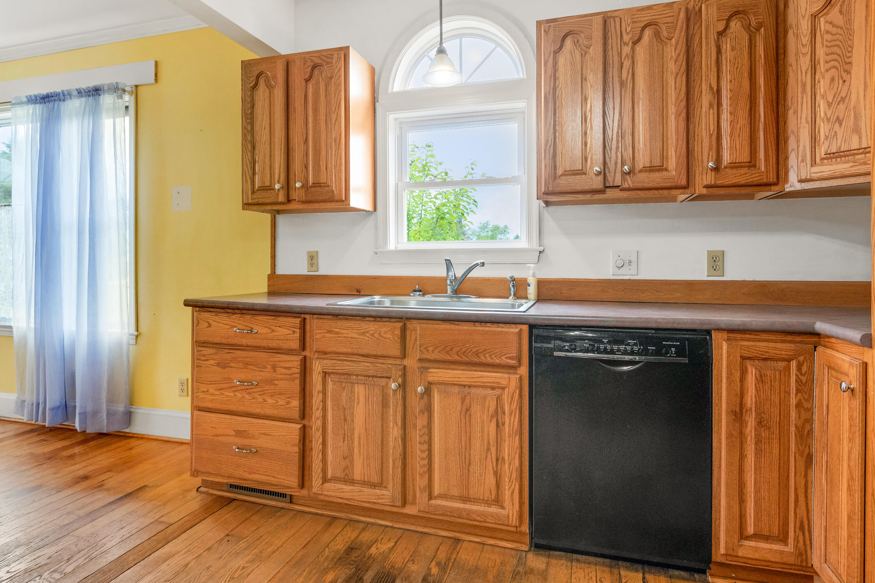 223 Conner Grove Road Southwest Willis, VA 24380 - Photo 18 of 74 a kitchen with stainless steel appliances granite countertop a sink dishwasher and wooden cabinets with wooden floor