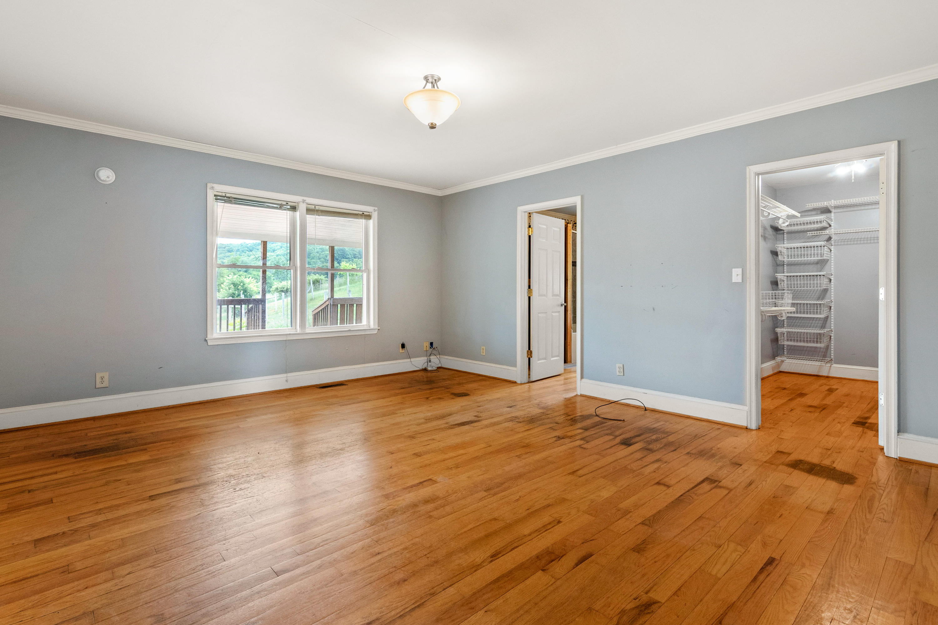 223 Conner Grove Road Southwest Willis, VA 24380 - Photo 27 of 74 a view of an empty room with window and wooden floor