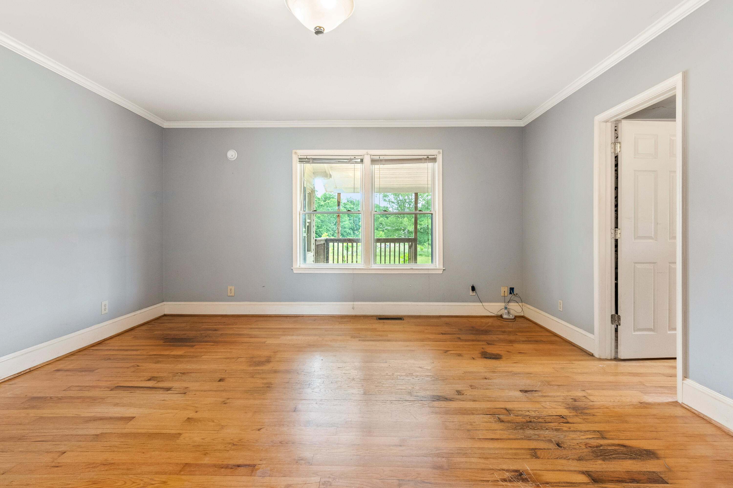 223 Conner Grove Road Southwest Willis, VA 24380 - Photo 29 of 74 a view of an empty room with wooden floor and a window