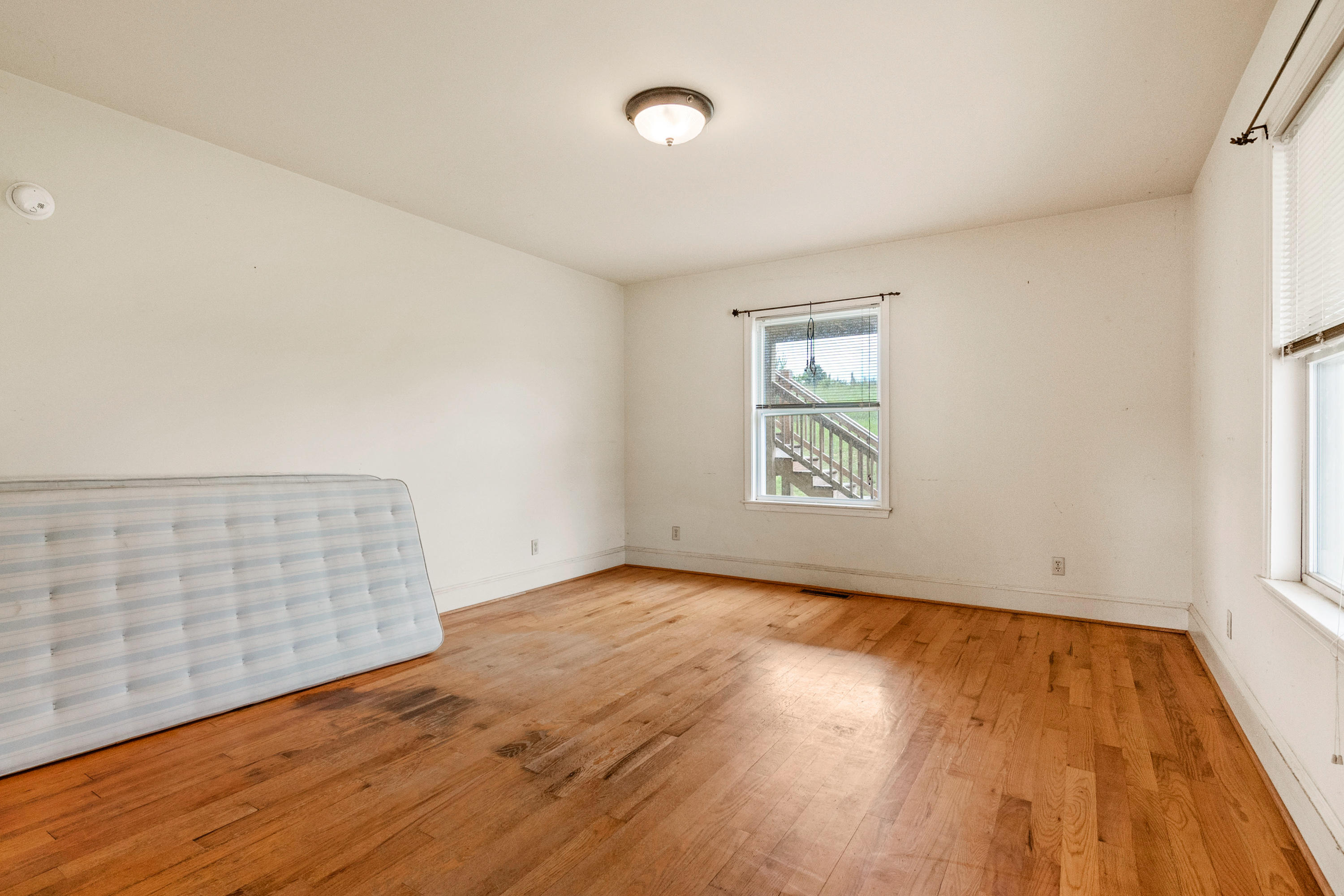 223 Conner Grove Road Southwest Willis, VA 24380 - Photo 33 of 74 an empty room with wooden floor and windows