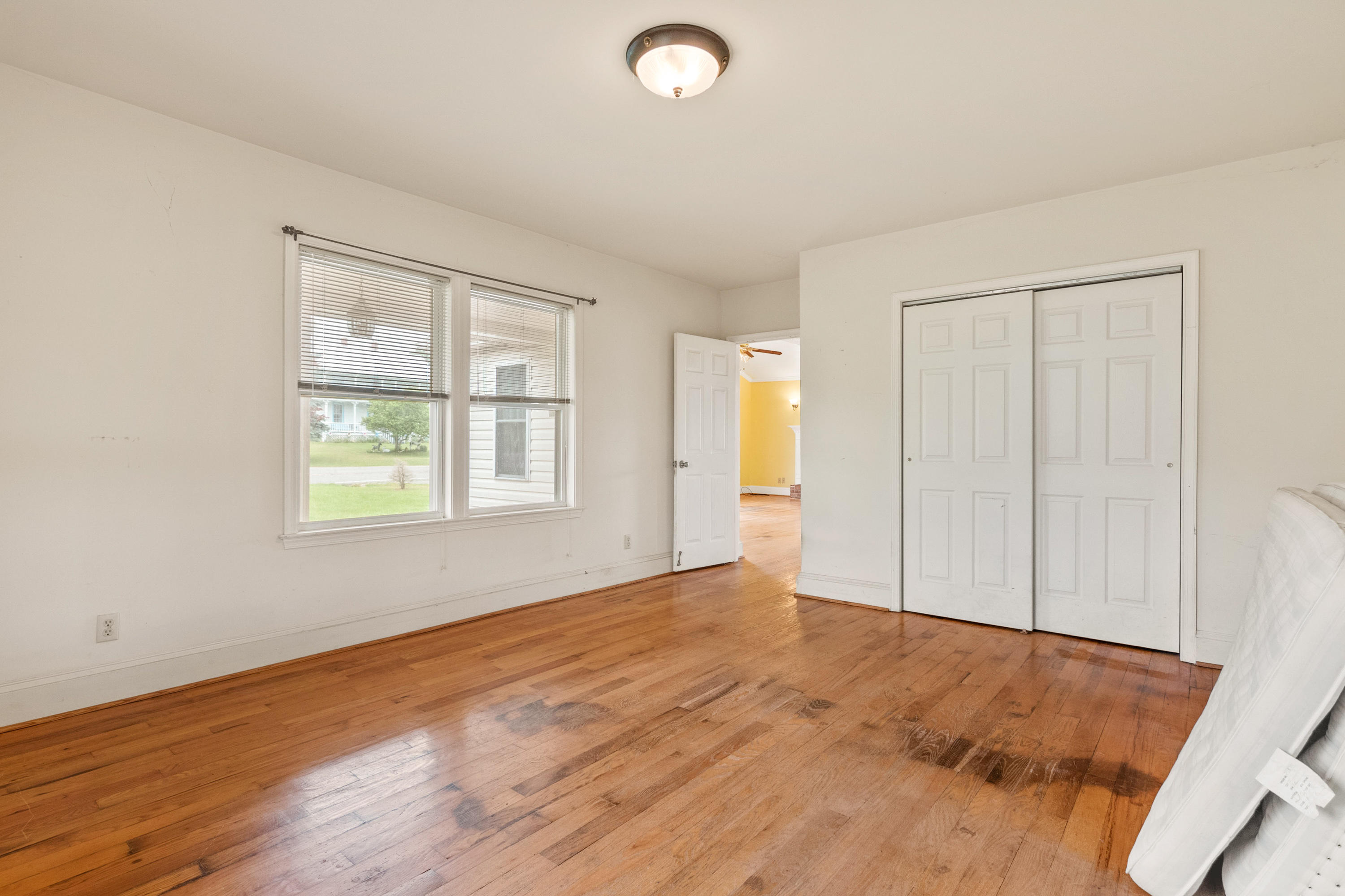 223 Conner Grove Road Southwest Willis, VA 24380 - Photo 34 of 74 an empty room with wooden floor and windows