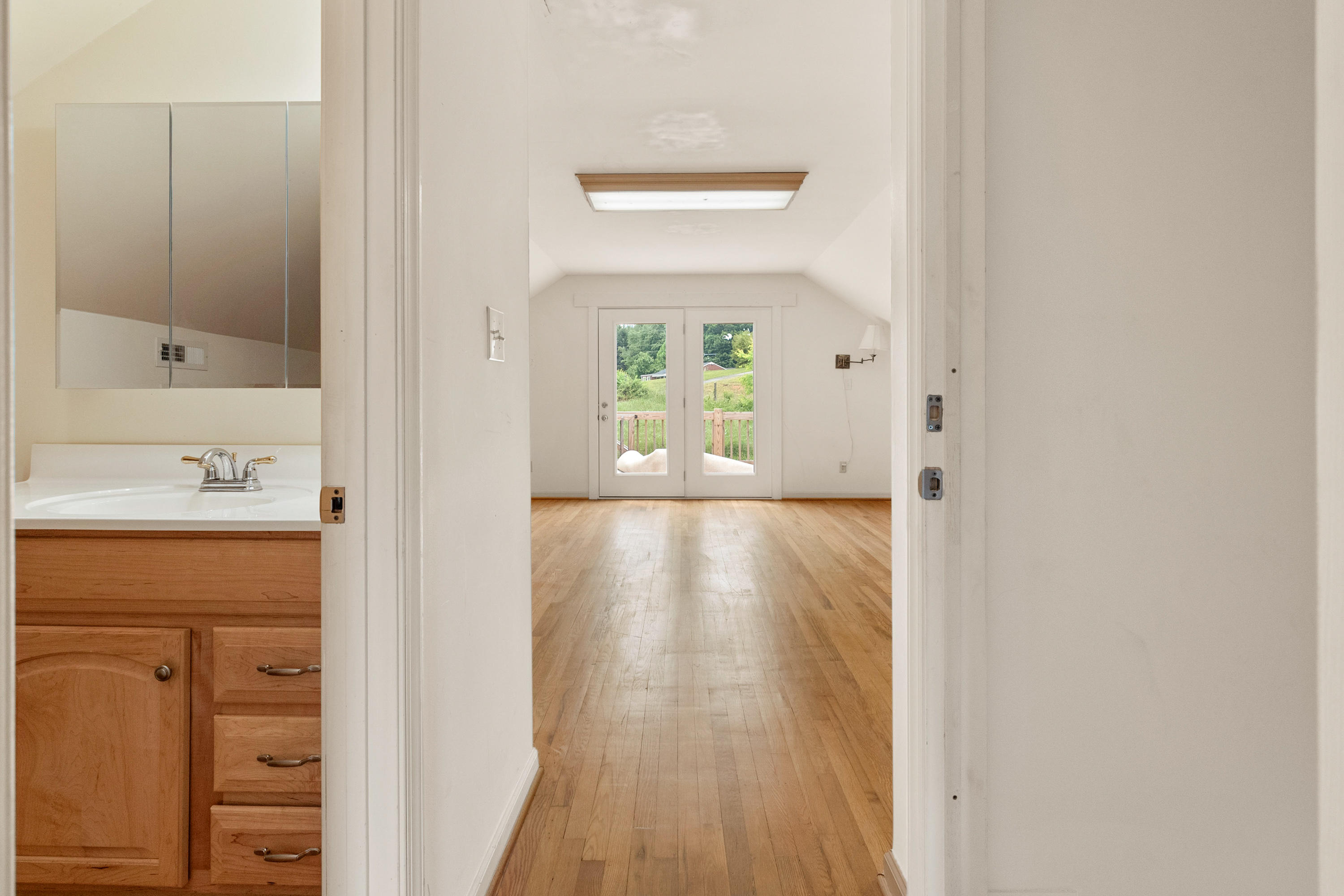 223 Conner Grove Road Southwest Willis, VA 24380 - Photo 35 of 74 a view of a hallway with wooden floor and a bathroom