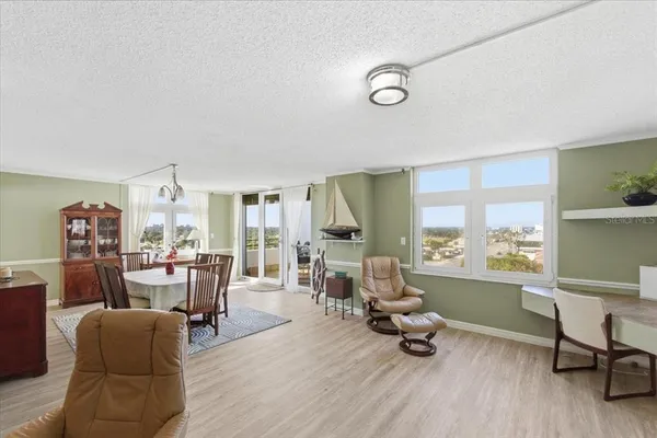 a view of a a dining room with furniture window and wooden floor