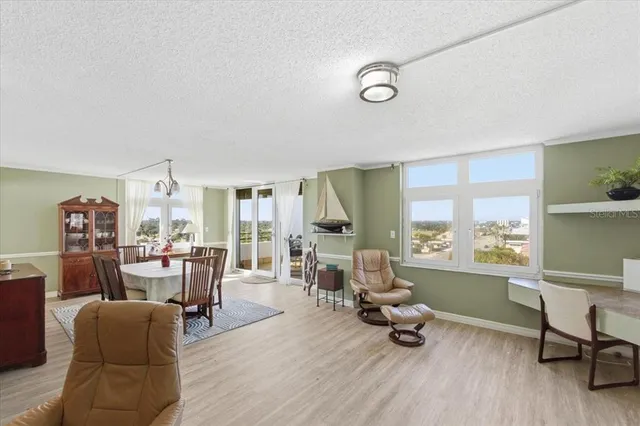 a view of a a dining room with furniture window and wooden floor
