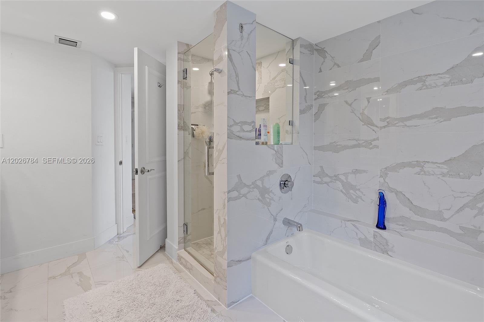 151 Southeast 15th Road, Unit 601 Miami, FL 33129 - Photo 23 of 36 a bathroom with a bathtub shower sink vanity and a shower