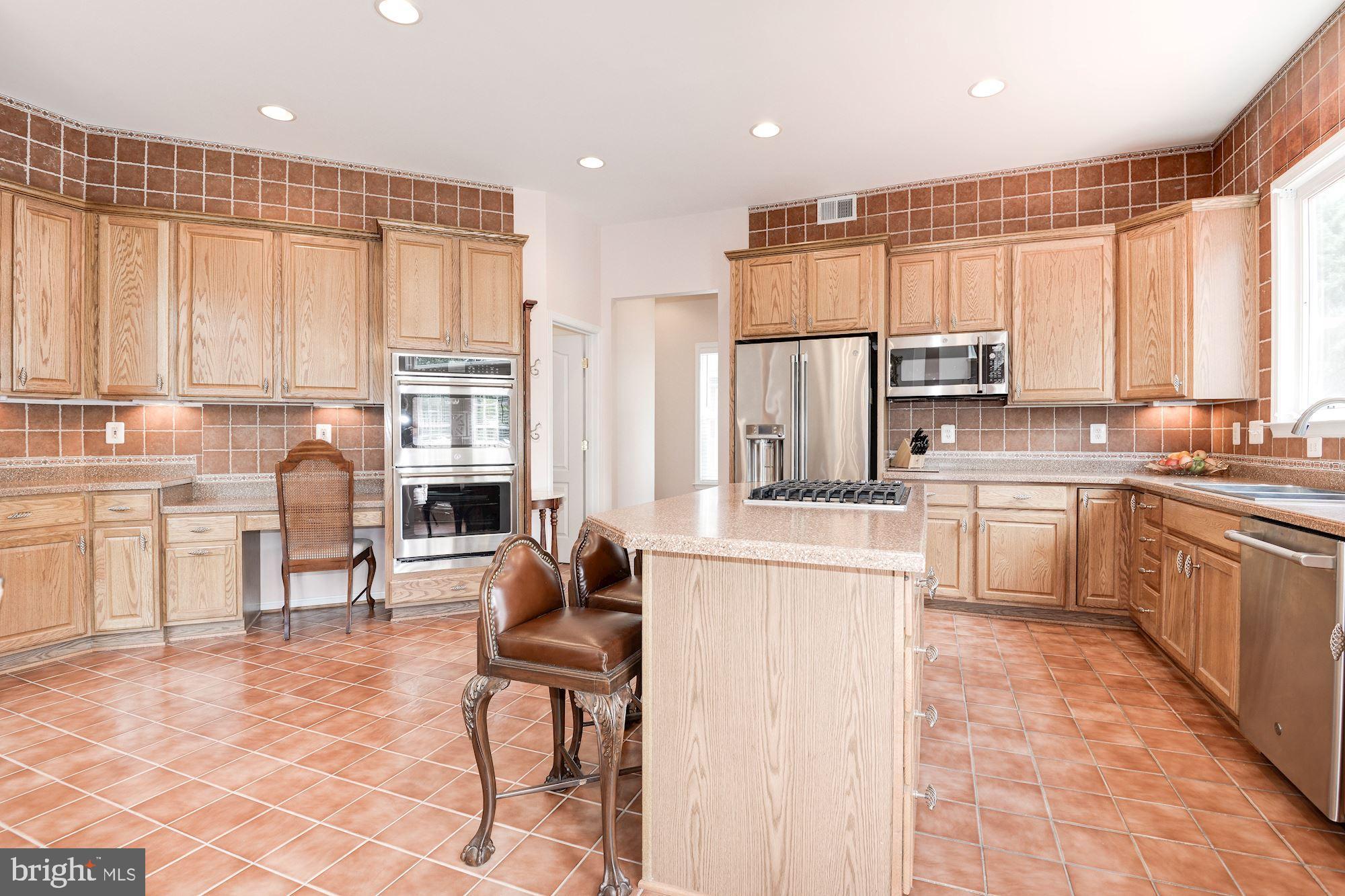 7104 Ayers Meadow Lane Springfield, VA 22150 - Photo 22 of 62 a kitchen with kitchen island granite countertop a stove a sink a dining table and chairs