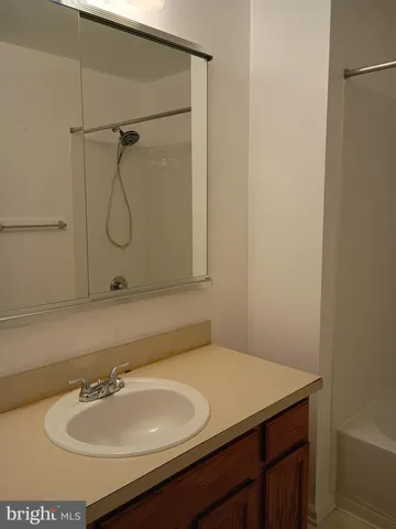 a bath tub sitting next to a white sink and vanity