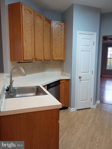 a kitchen with a sink a refrigerator and cabinets