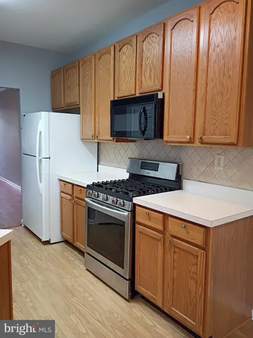 a kitchen with granite countertop stainless steel appliances a stove a refrigerator a sink a counter space and cabinets