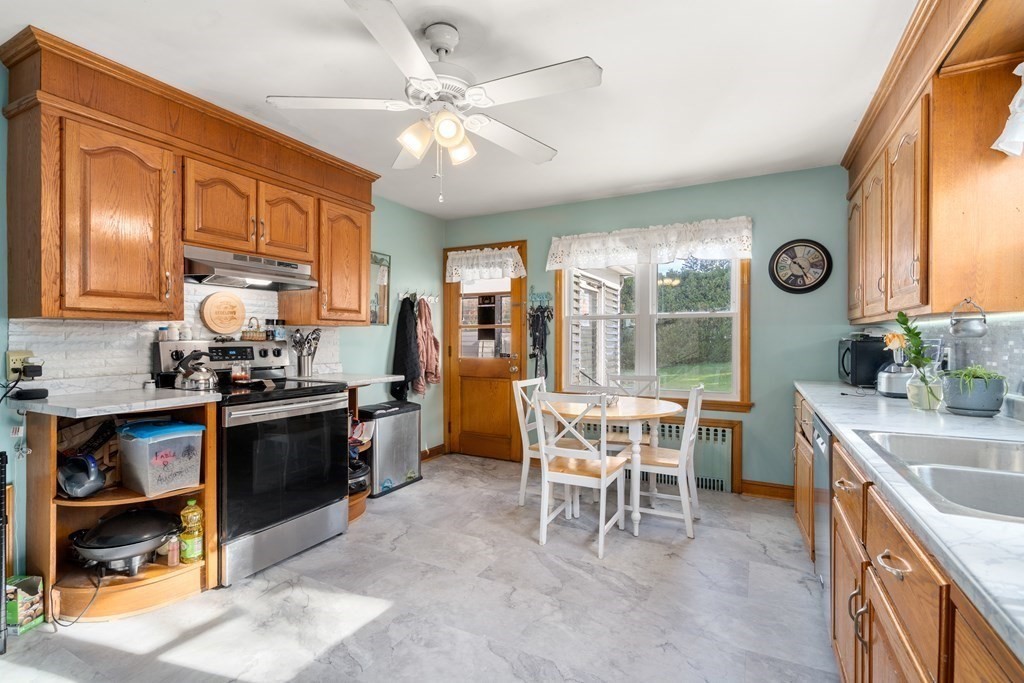 45 Ruggles Street Three Rivers, MA 01080 - Photo 10 of 29 a kitchen with a stove a refrigerator and a dining table