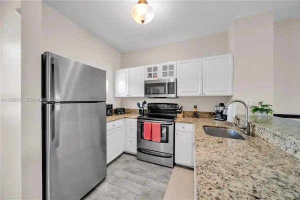 a kitchen with stainless steel appliances granite countertop a refrigerator stove top oven and sink
