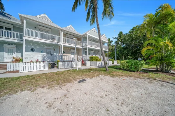 a view of a house with a yard and palm trees