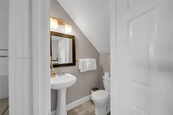 a bathroom with a sink toilet and mirror