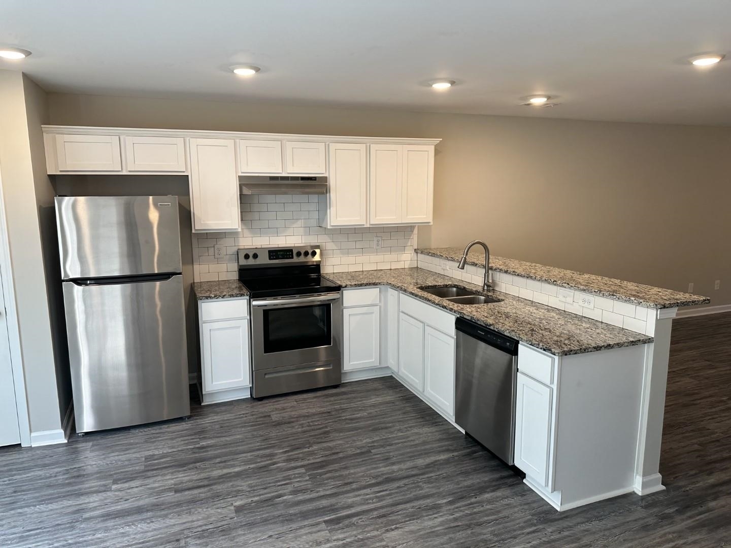 712 Keeshono St Union, Unit 712 Union City, GA 30291 - Photo 5 of 22 a kitchen with granite countertop a sink and a stove top oven