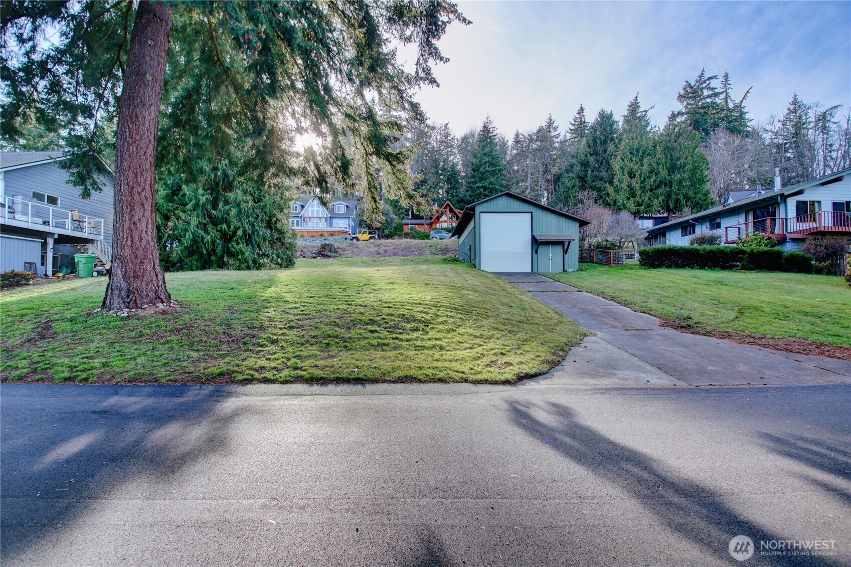 a view of a big house with a big yard and large trees