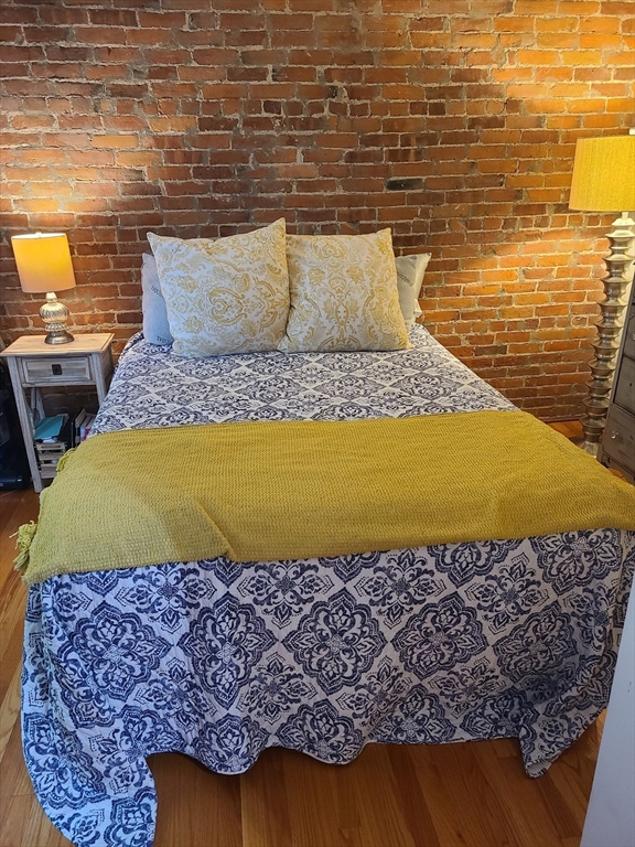 32 Fleet Street, Unit 5 Boston, MA 02113 - Photo 9 of 12 a bed sitting in a bedroom next to a body of water and a wall