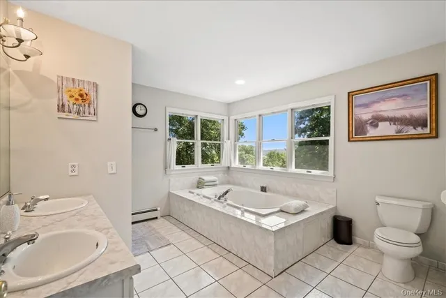 a bathroom with a tub sink toilet and mirror