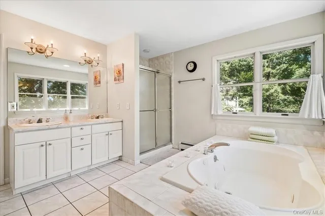 a spacious bathroom with a tub sink and mirror