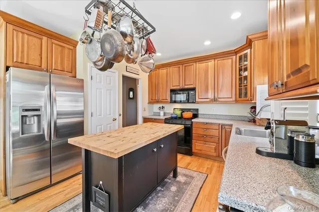 a kitchen with stainless steel appliances granite countertop a sink a stove and refrigerator