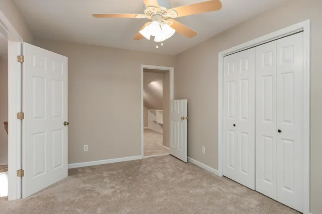 a view of an empty room and chandelier fan