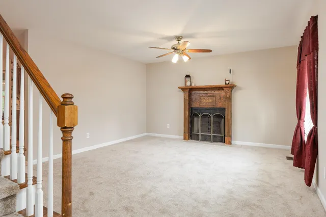 a view of an empty room with a fireplace and a window