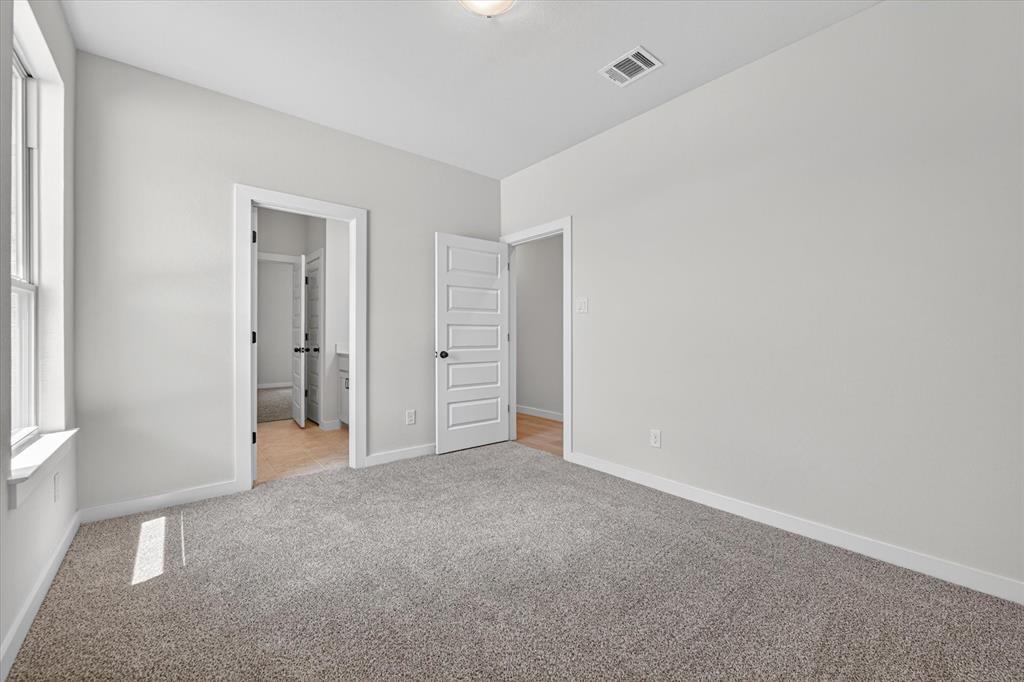 409 Mcalpine Springtown, TX 76082 - Photo 26 of 38 Spacious room with light gray wall paint, gray carpet, white trim, and a window with a white frame