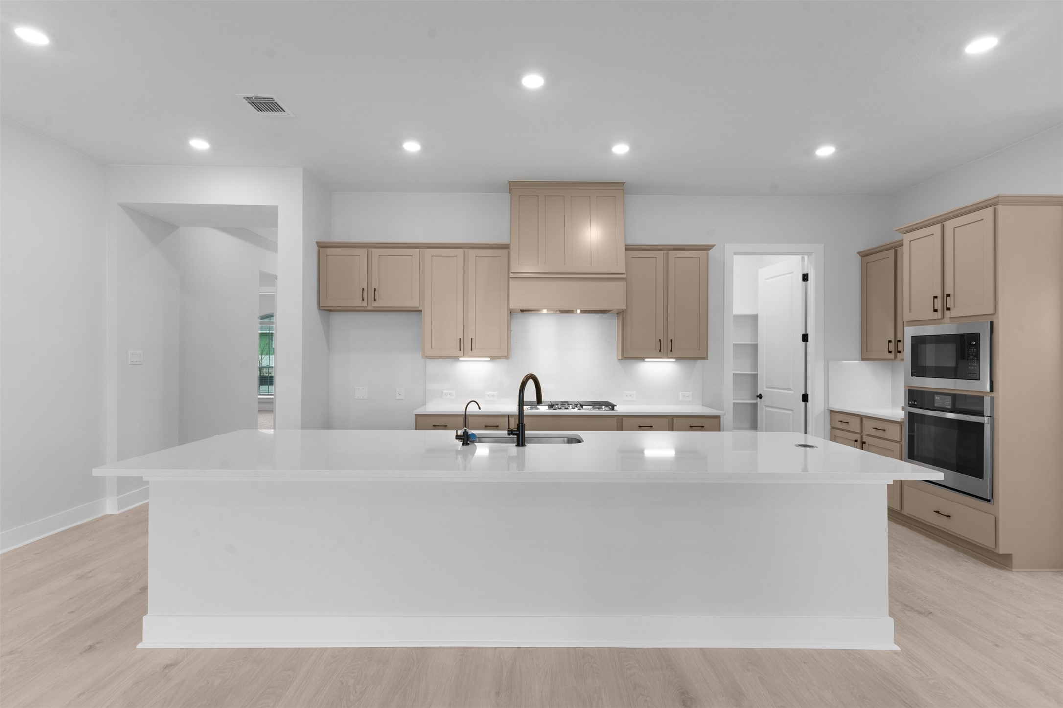 2212 Tobiano Trace Georgetown, TX 78633 - Photo 11 of 26 a large kitchen with stainless steel appliances a large counter top a stove and a refrigerator with wooden floor