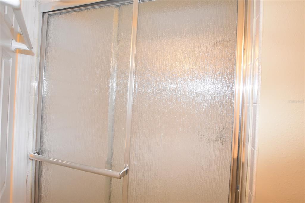 5323 Indian Creek Drive, Unit D Orlando, FL 32811 - Photo 17 of 23 a bathroom with a glass shower door
