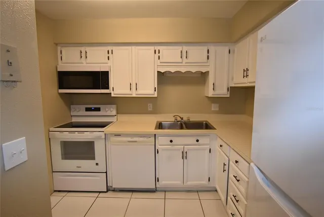 a kitchen with a refrigerator stove and white cabinets