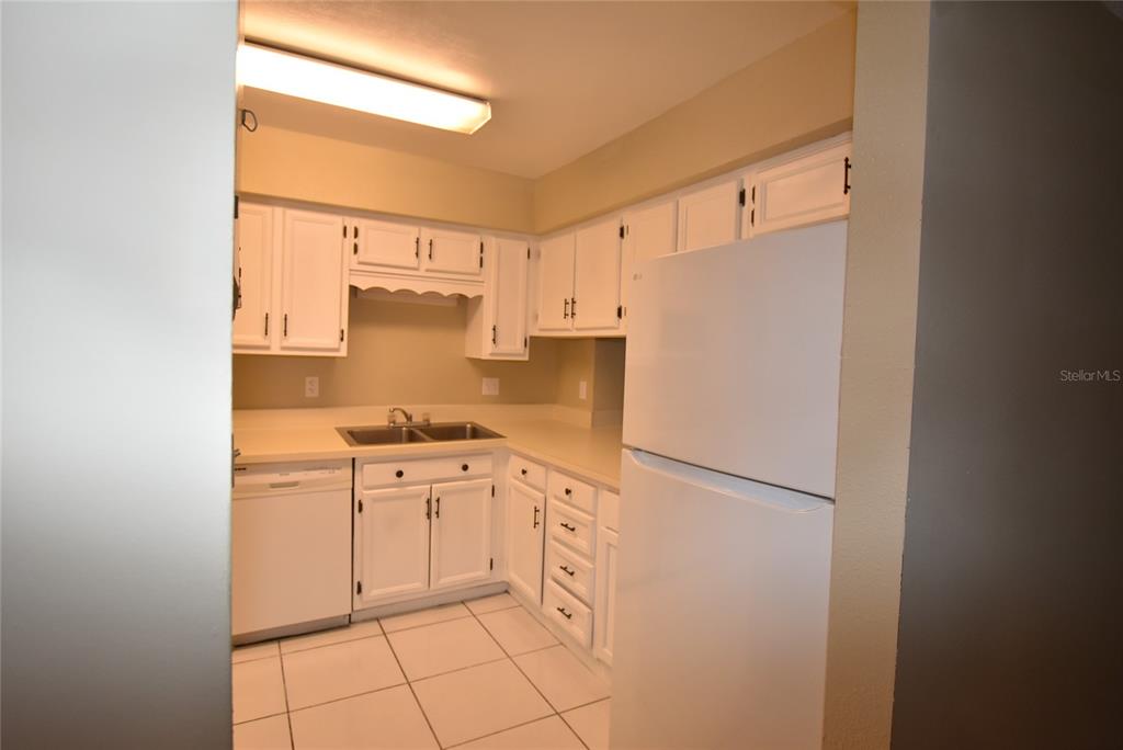 5323 Indian Creek Drive, Unit D Orlando, FL 32811 - Photo 23 of 23 a kitchen with stainless steel appliances a refrigerator sink and cabinets