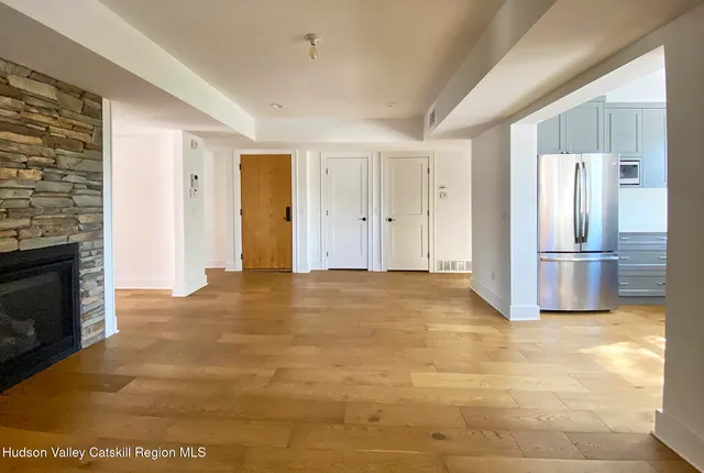 a view of empty room with a fireplace and wooden floor