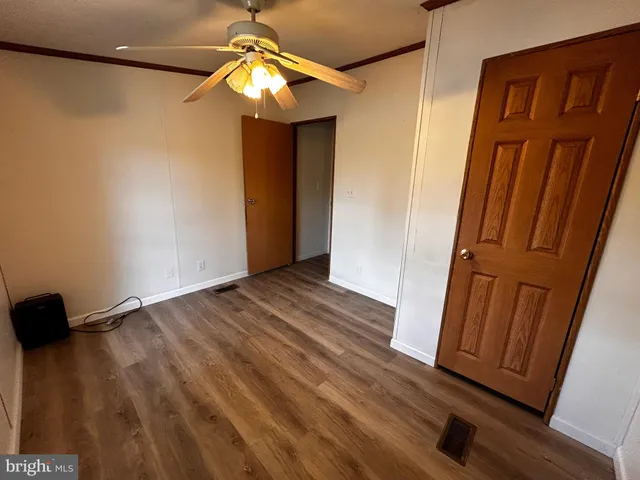 a view of a hallway with wooden floor and chandelier