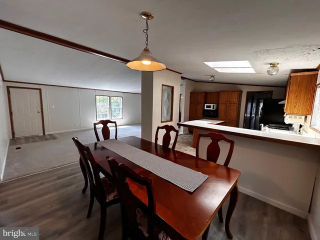 a view of a a dining room with furniture window and wooden floor
