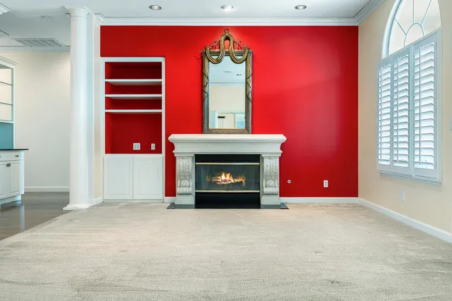a view of an empty room with a fireplace and a window