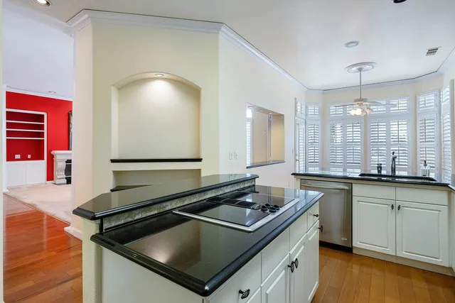 a kitchen with granite countertop stainless steel appliances and wooden floor