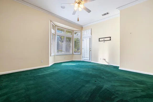 a view of a big room with windows and chandelier fan