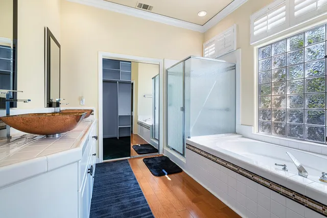 a spacious bathroom with a double vanity sink a mirror and a shower