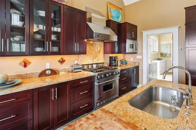 a kitchen with stainless steel appliances granite countertop a sink stove and cabinets