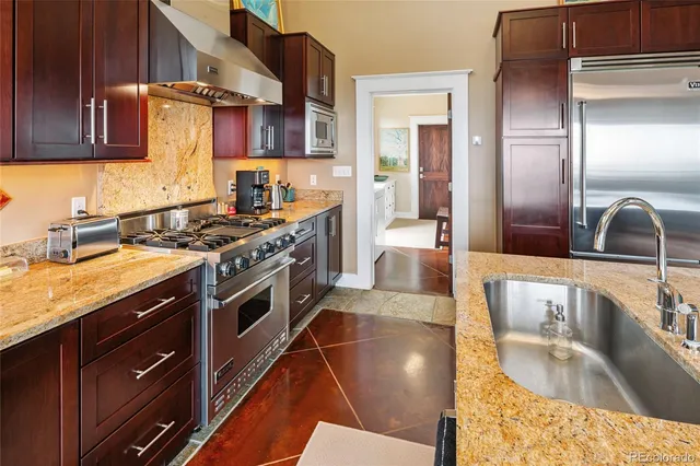 a kitchen with stainless steel appliances granite countertop a sink stove and cabinets