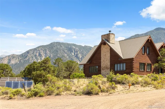 a view of a big house with a big yard and large tree