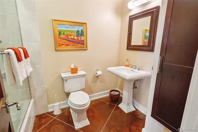 a bathroom with a toilet a sink and a mirror