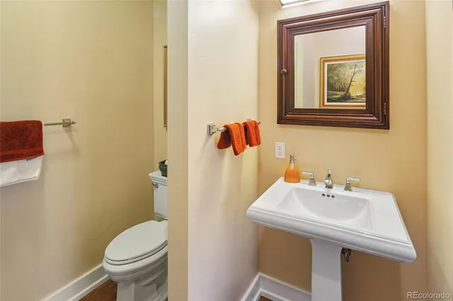 a bathroom with a sink and mirror with toilet
