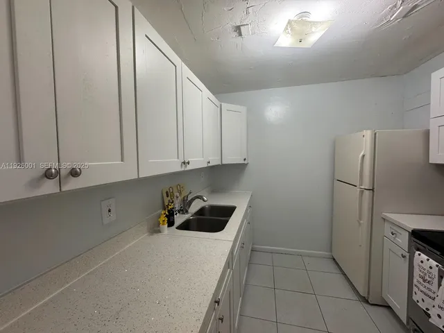 a kitchen with cabinets and refrigerator