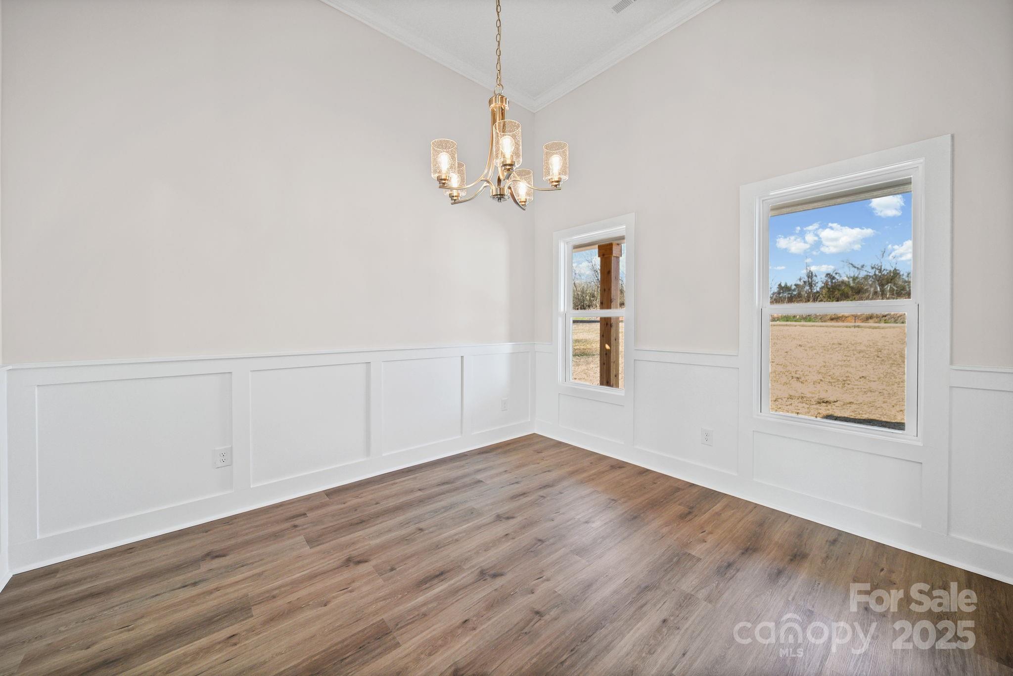 4106 New Salem Road Marshville, NC 28103 - Photo 16 of 46 an empty room with wooden floor chandelier and windows