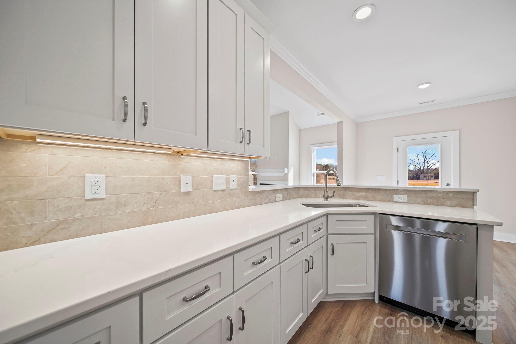 4106 New Salem Road Marshville, NC 28103 - Photo 18 of 46 a kitchen with a sink dishwasher and white cabinets with wooden floor