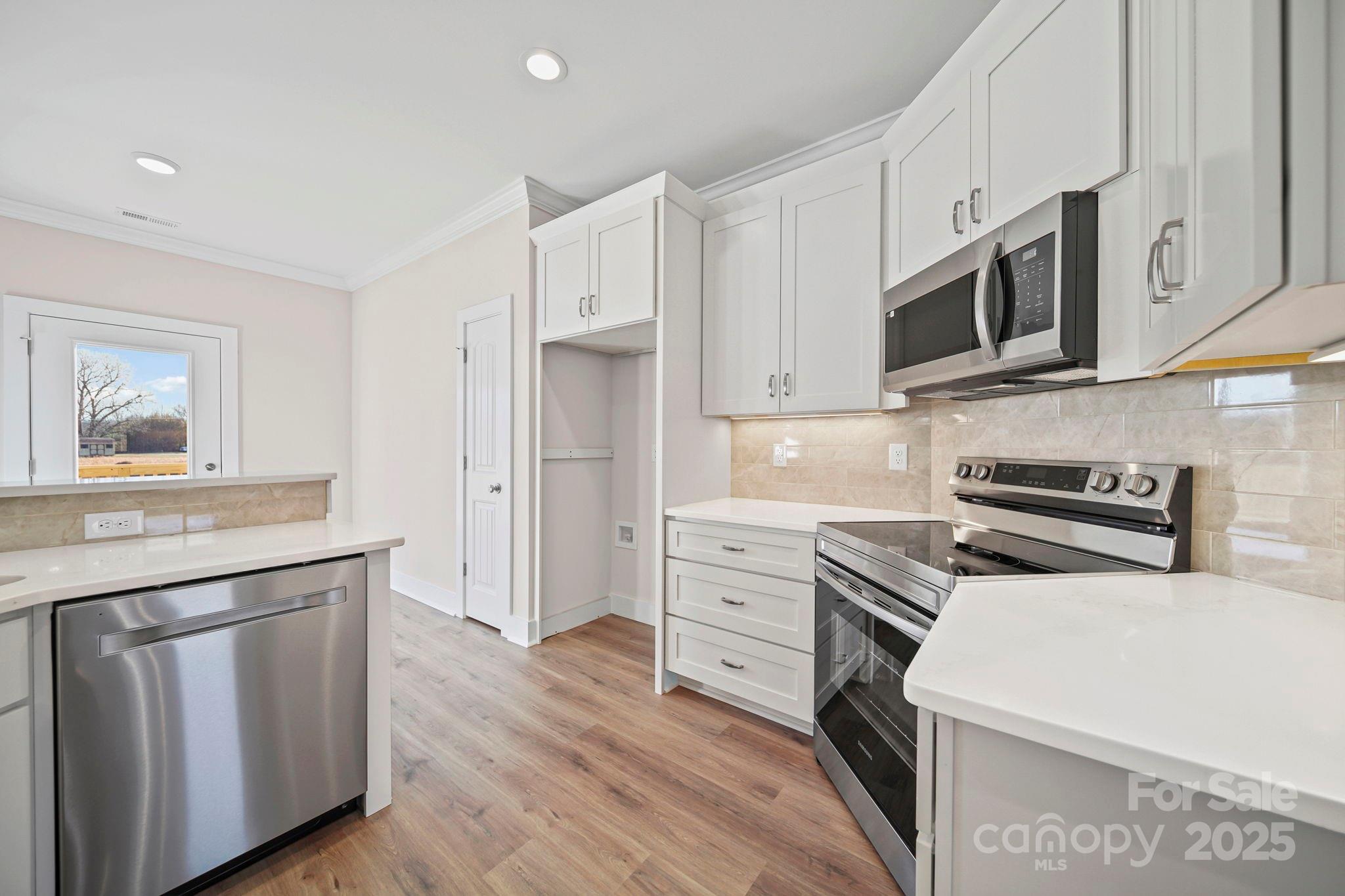 4106 New Salem Road Marshville, NC 28103 - Photo 19 of 46 a kitchen with stainless steel appliances a stove microwave and cabinets