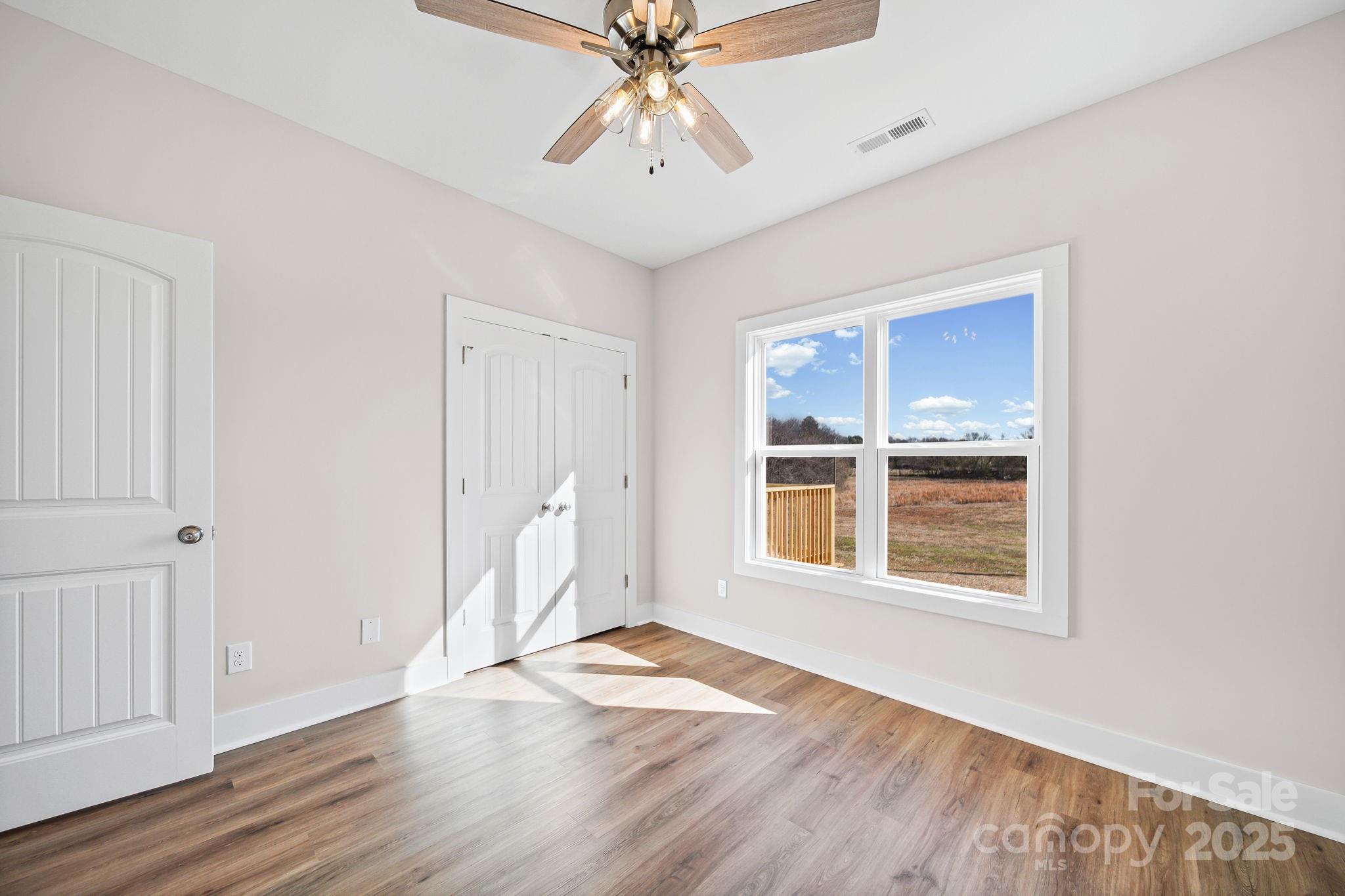 4106 New Salem Road Marshville, NC 28103 - Photo 36 of 46 an empty room with wooden floor chandelier and windows