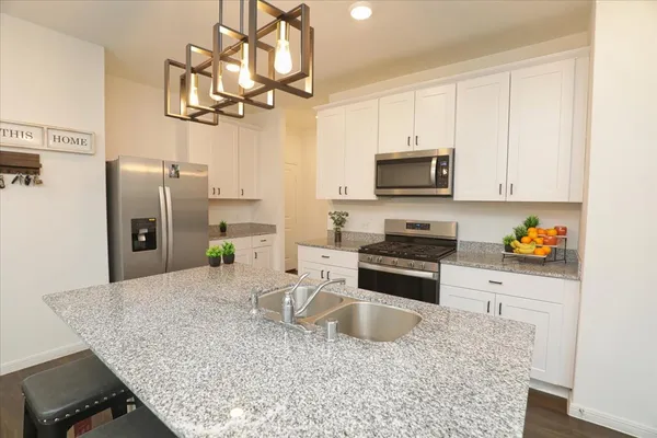 a kitchen with stainless steel appliances granite countertop a sink refrigerator and microwave